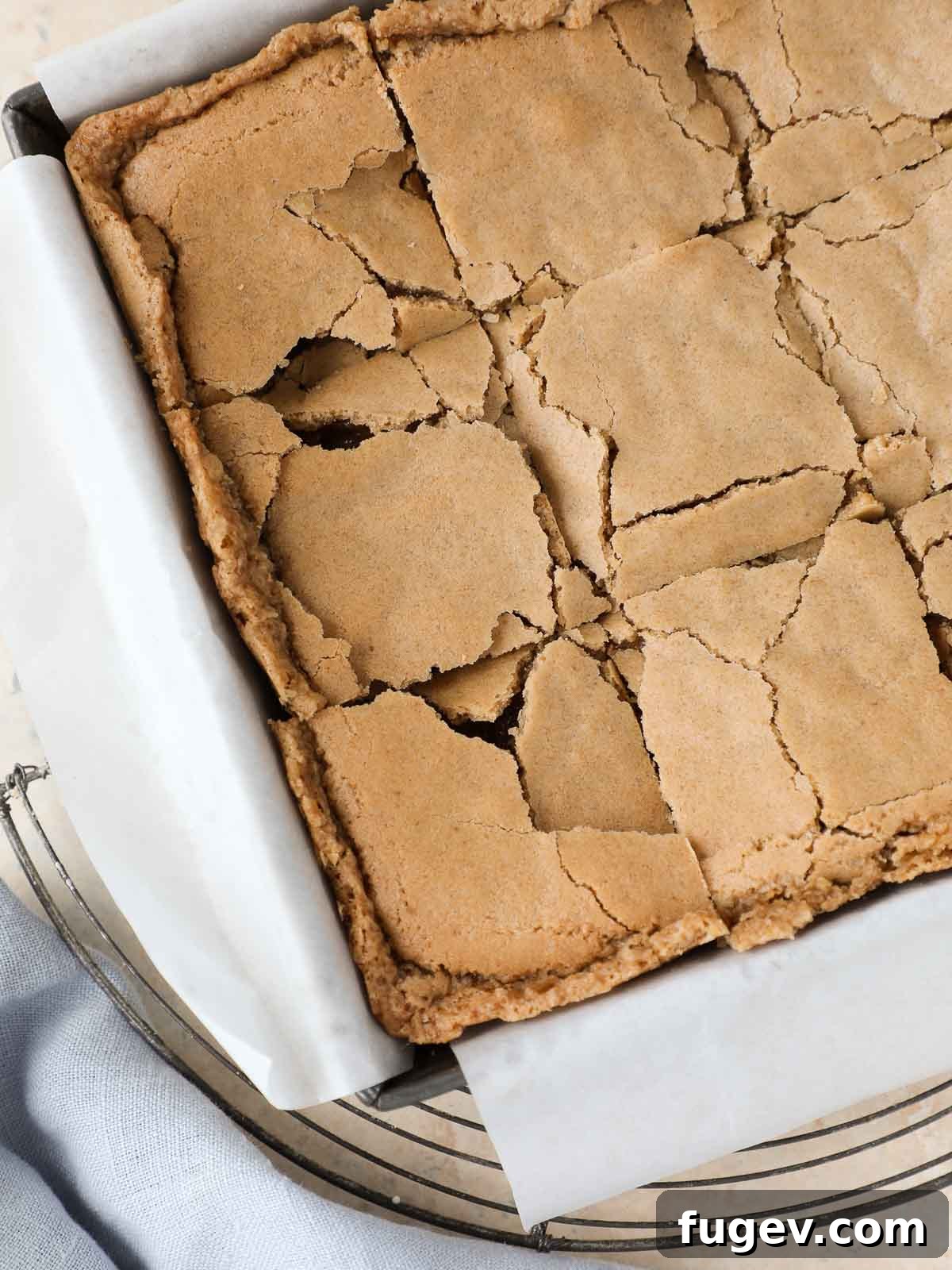 Butterscotch Blondies 2 Sliced butterscotch brownies in a pan on a cooling rack, showcasing their chewy texture and golden-brown crust.
