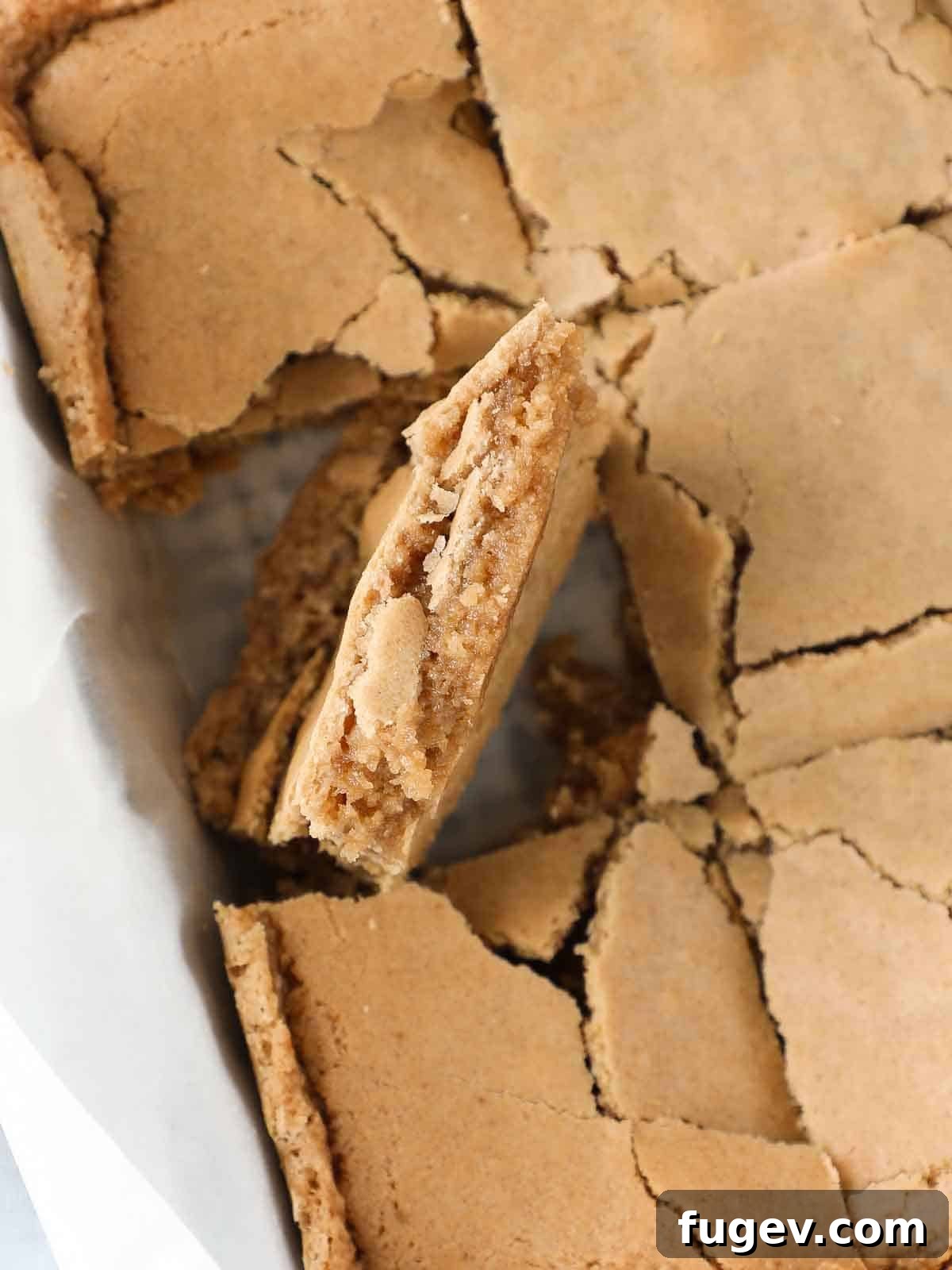 Butterscotch Blondies 14 Sliced butterscotch brownies in a pan, with one brownie turned on its side to reveal the thick, chewy interior and crinkly top.