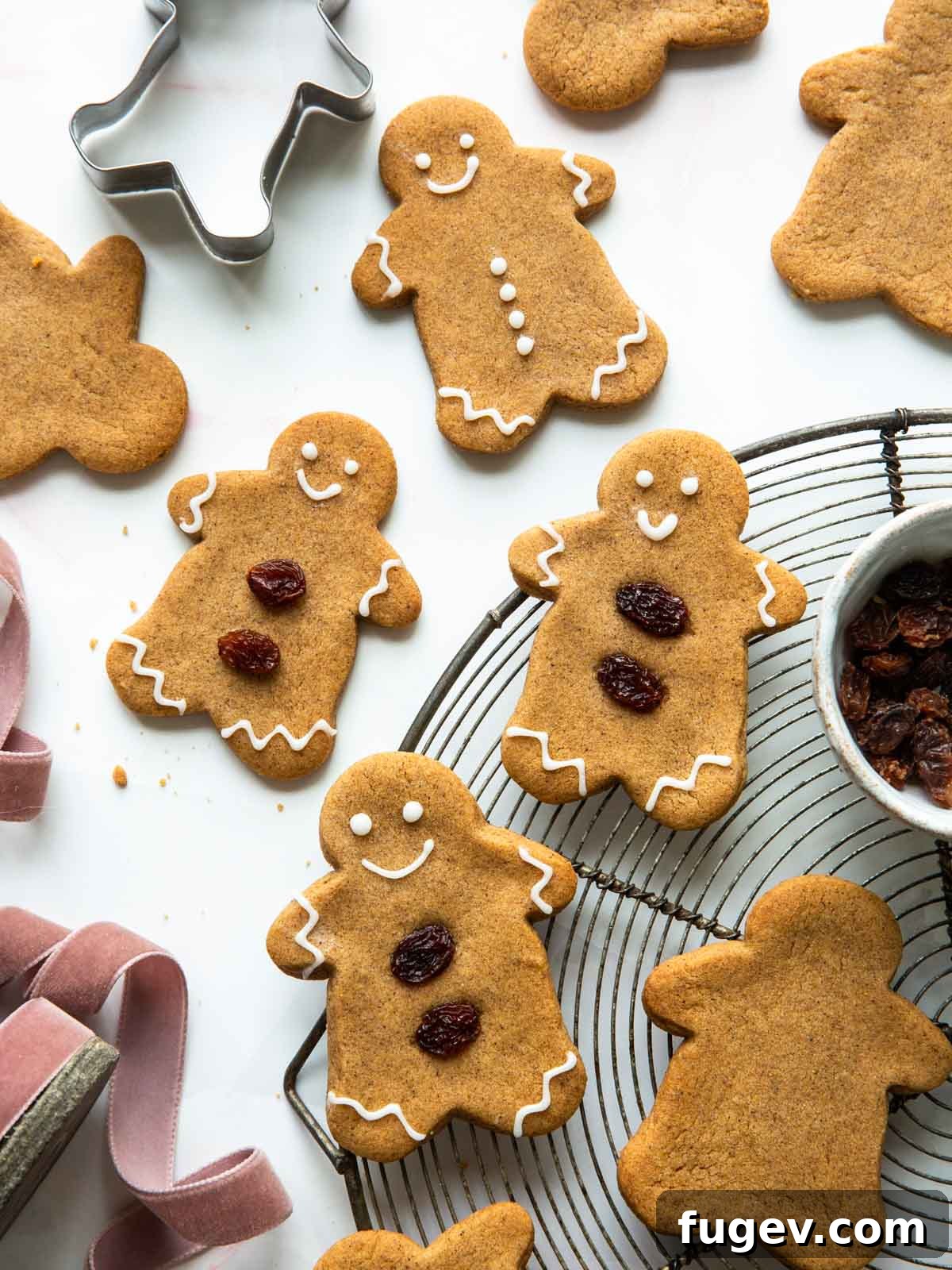20 Festive Christmas Cookie Recipes 3 gingerbread cookies on wire rack and table.
