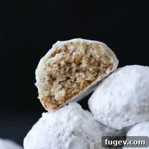 20 Festive Christmas Cookie Recipes 41 Easy Christmas cookies, pecan snowball cookies against a black backgorund.
