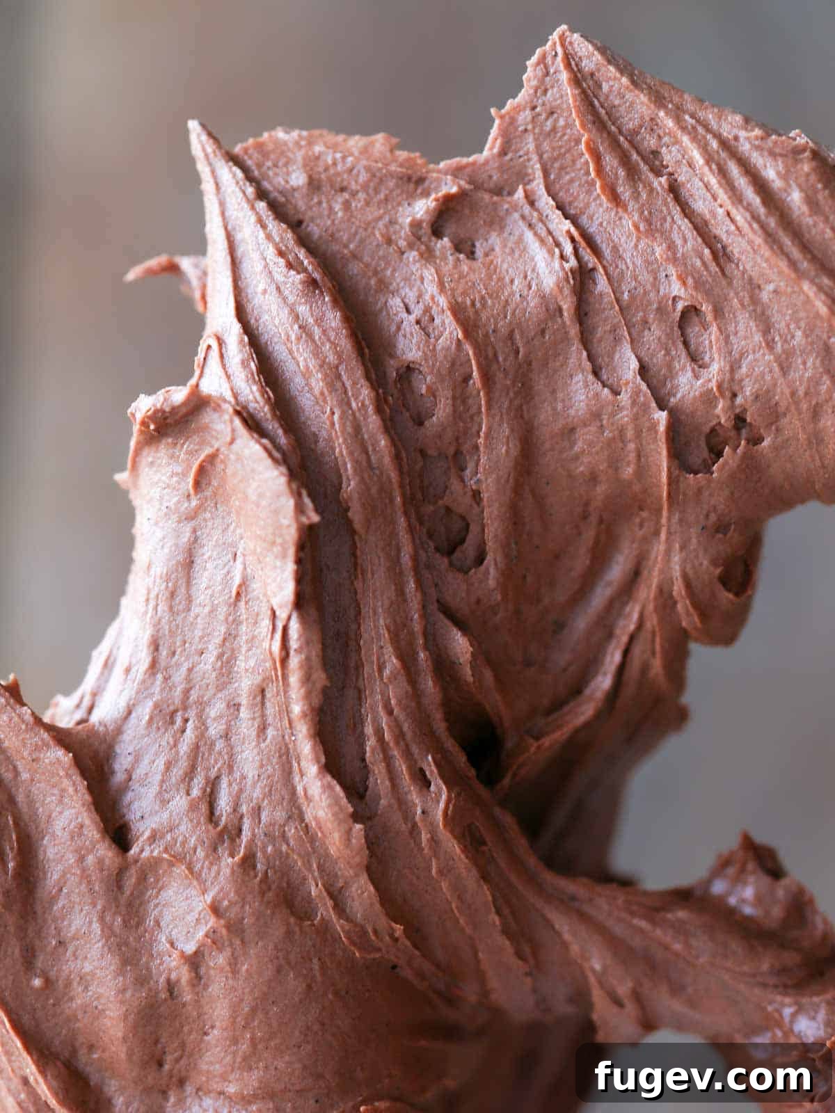 Decadent Chocolate Buttercream 2 Swirls of rich chocolate buttercream frosting on a paddle attachment, showcasing its smooth and creamy texture.