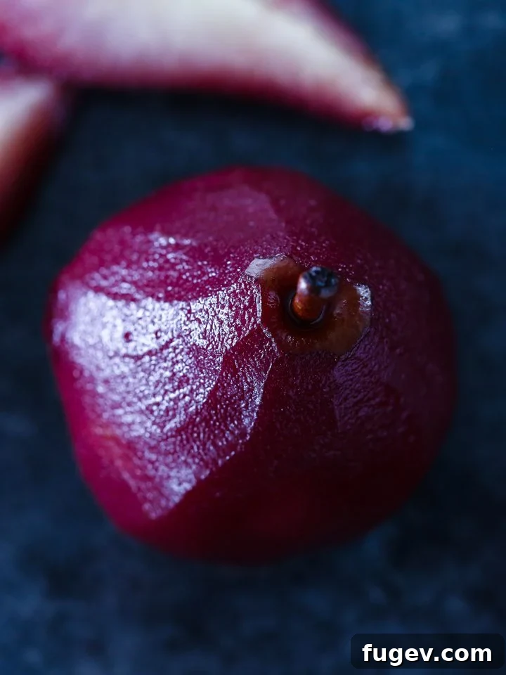 Crimson Poached Pears 3 Two red wine poached pears on a white plate