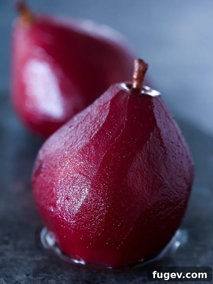 Crimson Poached Pears 6 Two red wine poached pears on a festive plate with berries