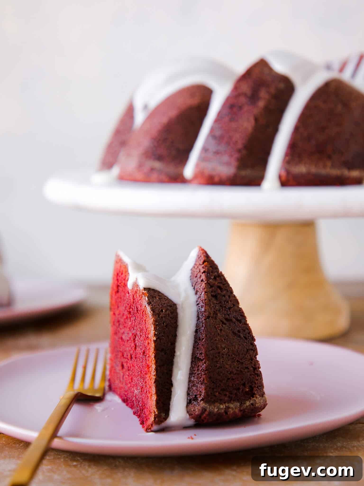 Ultimate Red Velvet Loaf Cake 2 Slice of Red Velvet Pound Cake with cream cheese glaze, whole cake in background. Perfect for Valentine's Day Desserts.