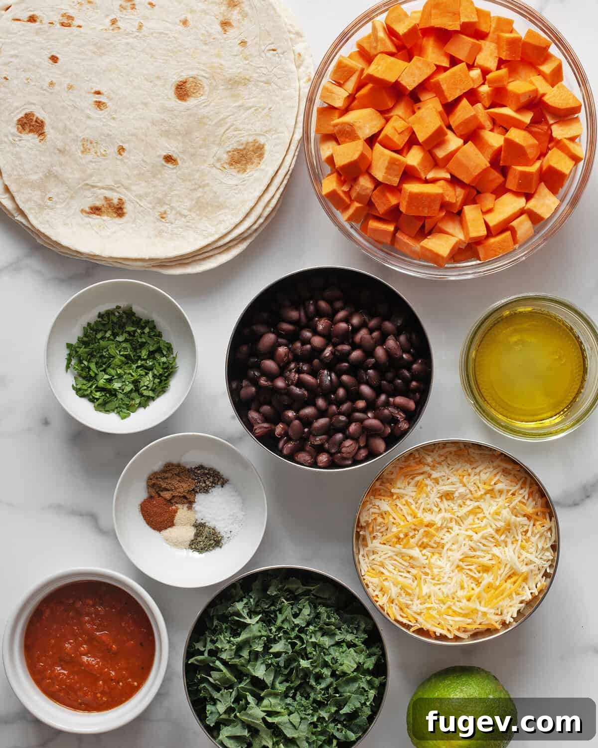 Savory Roasted Sweet Potato Black Bean Quesadillas 3 A vibrant spread of ingredients for sweet potato black bean quesadillas, including diced sweet potatoes, canned black beans, fresh kale, tortillas, shredded cheese, spices, cilantro, salsa, and lime wedges.