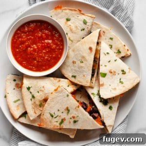 Sweet potato black bean quesadillas cut into triangles on a plate.