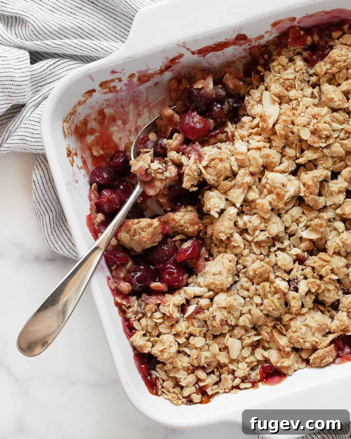 Quick Delicious Cherry Crumble 2 A generous portion of cherry crumble, freshly spooned from a baking dish, revealing the rich fruit filling and golden brown topping.