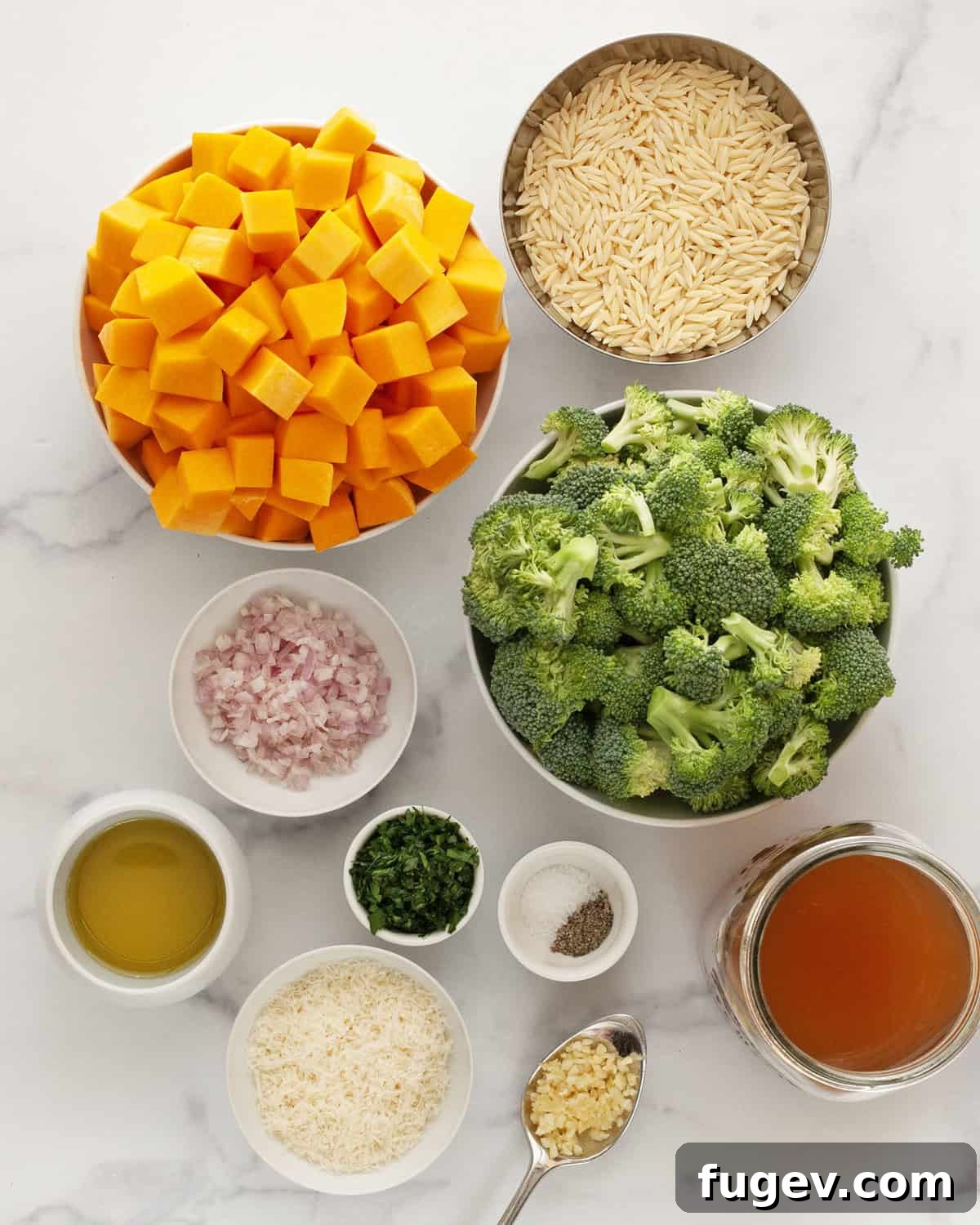 Hearty Roasted Butternut Squash and Broccoli Orzo 3 Arrangement of fresh ingredients including butternut squash, broccoli florets, orzo pasta, shallots, garlic cloves, olive oil, Parmesan cheese, and vegetable broth.