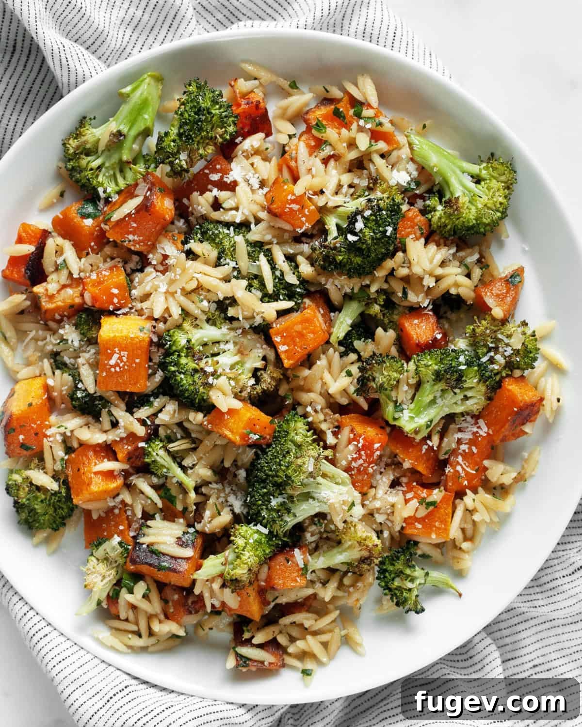 Hearty Roasted Butternut Squash and Broccoli Orzo 8 A plate of roasted butternut squash and broccoli orzo, garnished with fresh herbs.