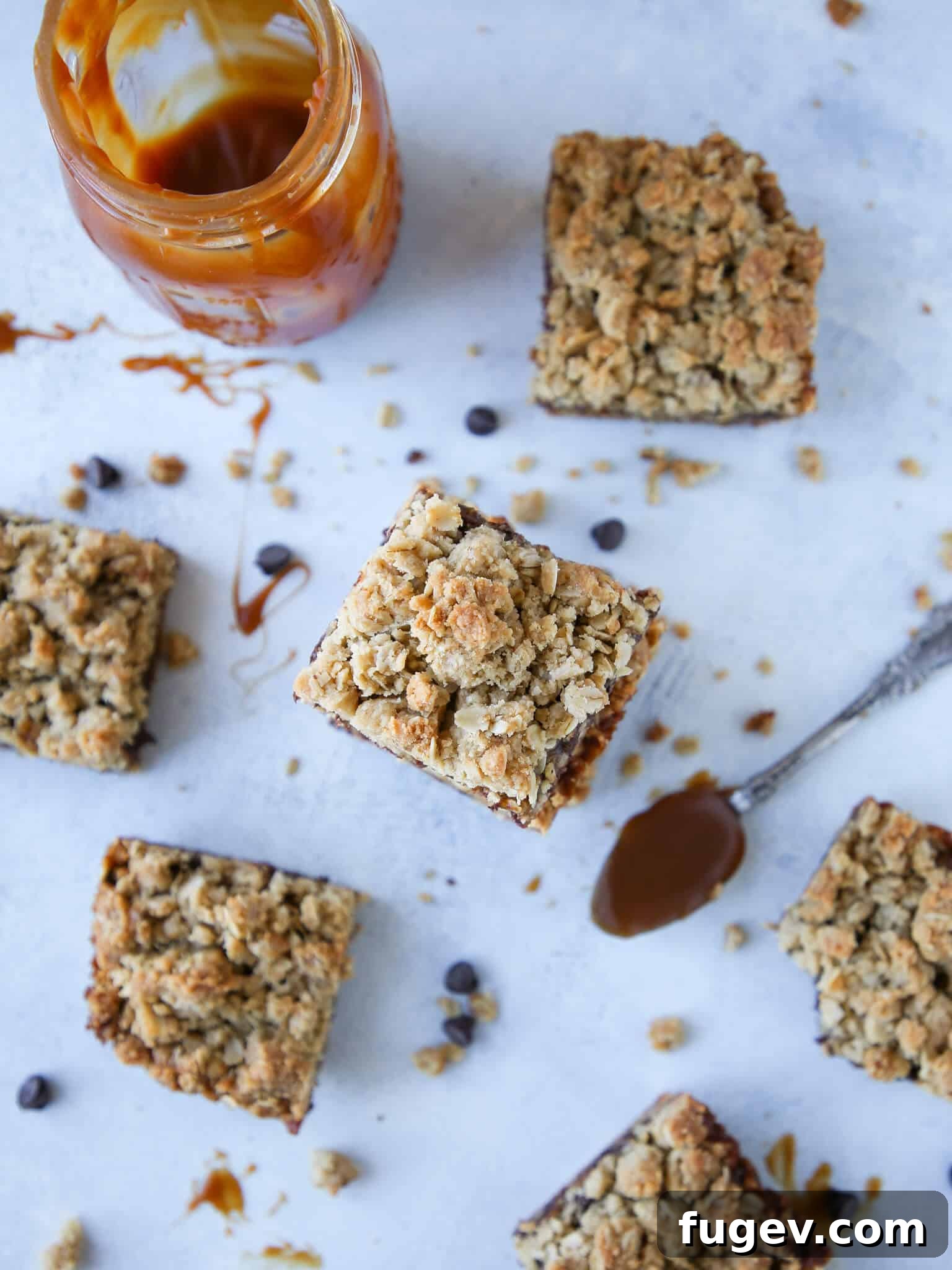 Chewy Caramel Oat Bars 3 Caramelita Cookie Bars arranged beautifully on a blue surface, drizzled with caramel