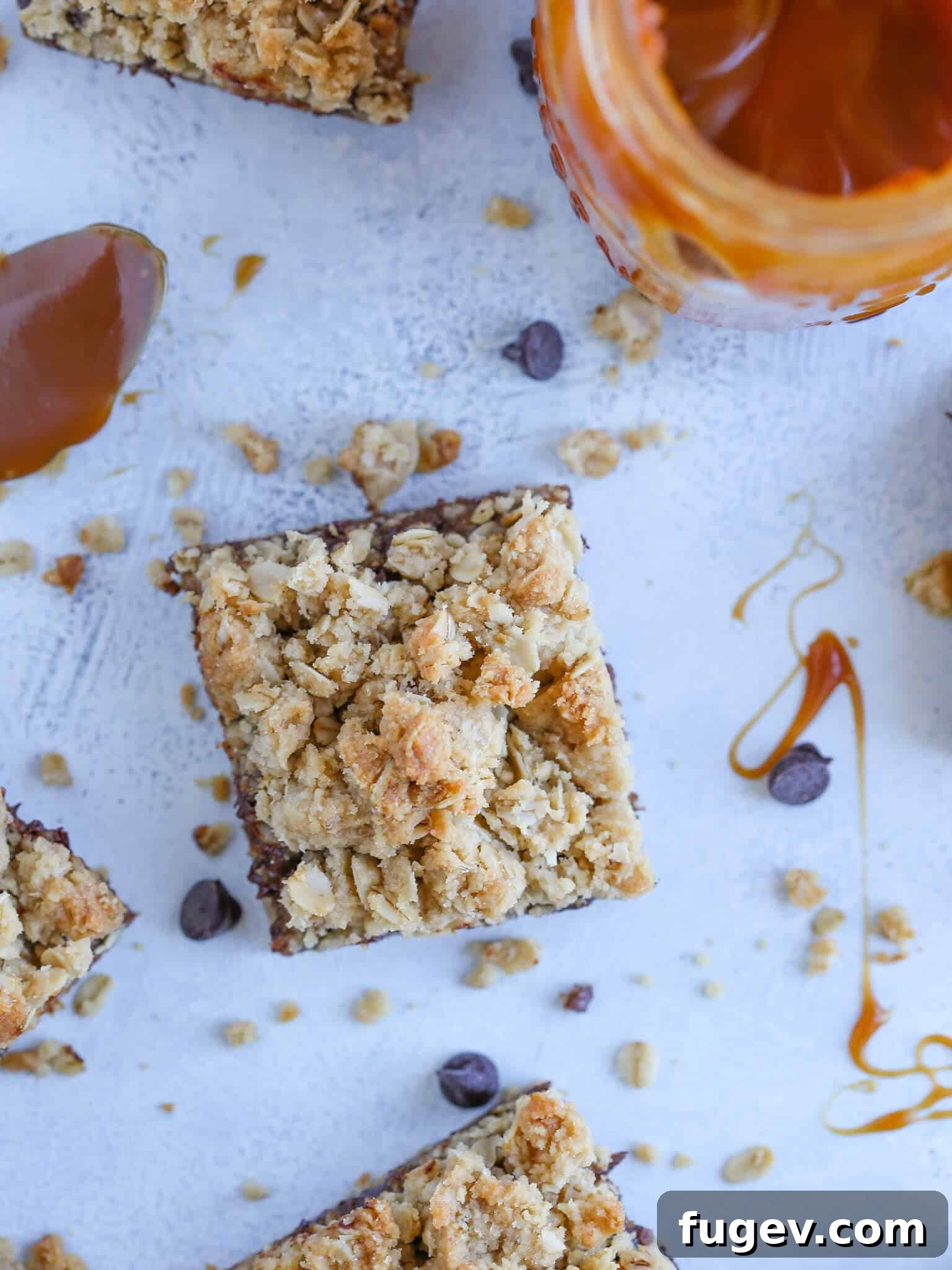 Chewy Caramel Oat Bars 5 Top-down detailed view of Caramelita Cookie Bars on a blue surface, showing chocolate chips and caramel