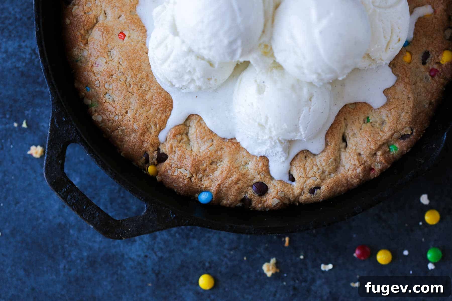 Deep Dish Cookie 5 Melting ice cream on a warm pizookie in a cast iron skillet, ready to be served.