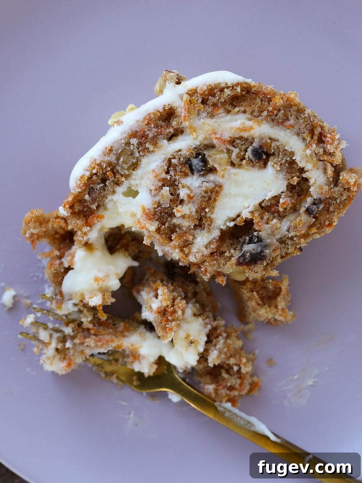 Spiced Carrot Cake Swirl 4 A beautifully rolled carrot cake roll with cream cheese frosting on top, ready for serving.