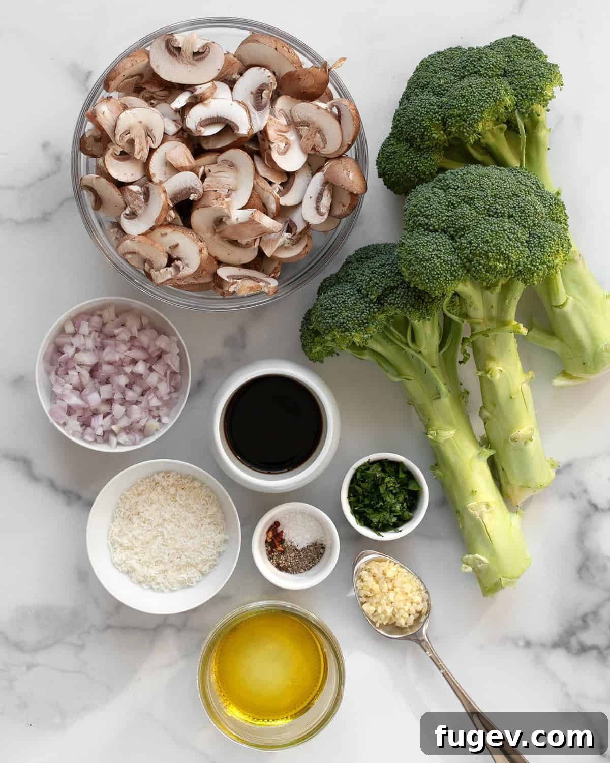 Balsamic Glazed Mushroom and Broccoli Rice 3 An array of fresh ingredients including whole broccoli, sliced mushrooms, balsamic vinegar, olive oil, parmesan cheese, red pepper flakes, salt, pepper, fresh parsley, shallots, and garlic, laid out on a wooden surface.