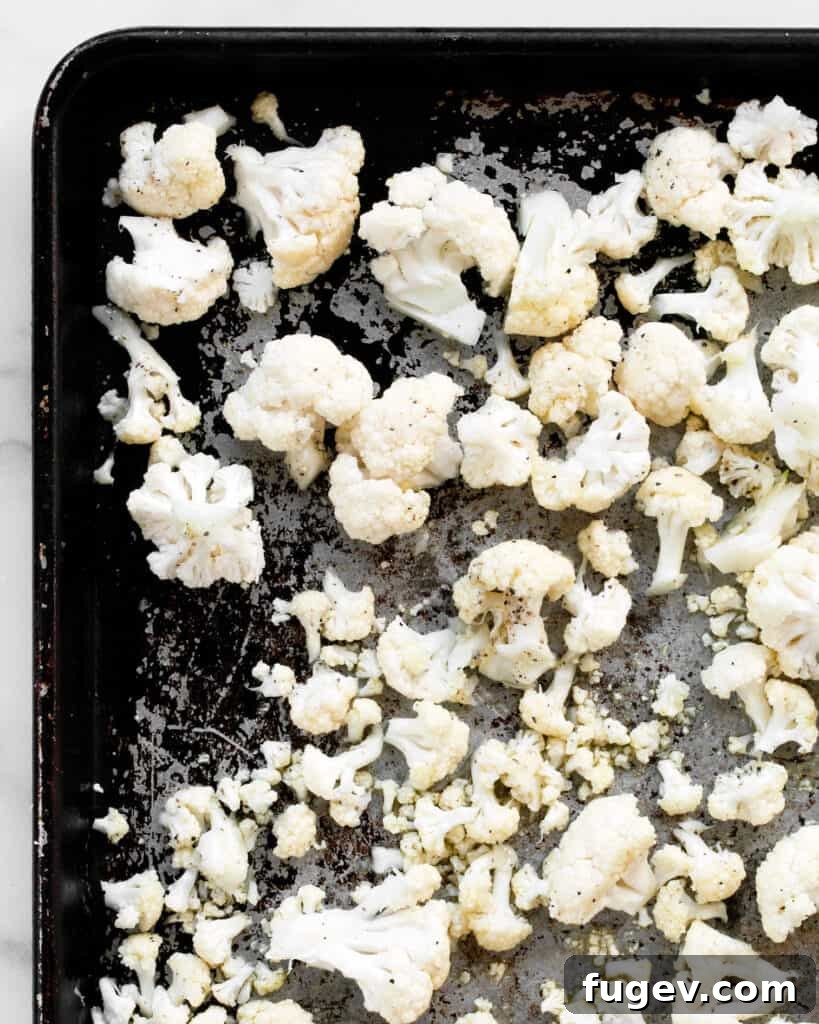 Golden Roasted Cauliflower Tapenade Pizza 6 Close-up of cauliflower florets seasoned and arranged on a sheet pan, ready for roasting
