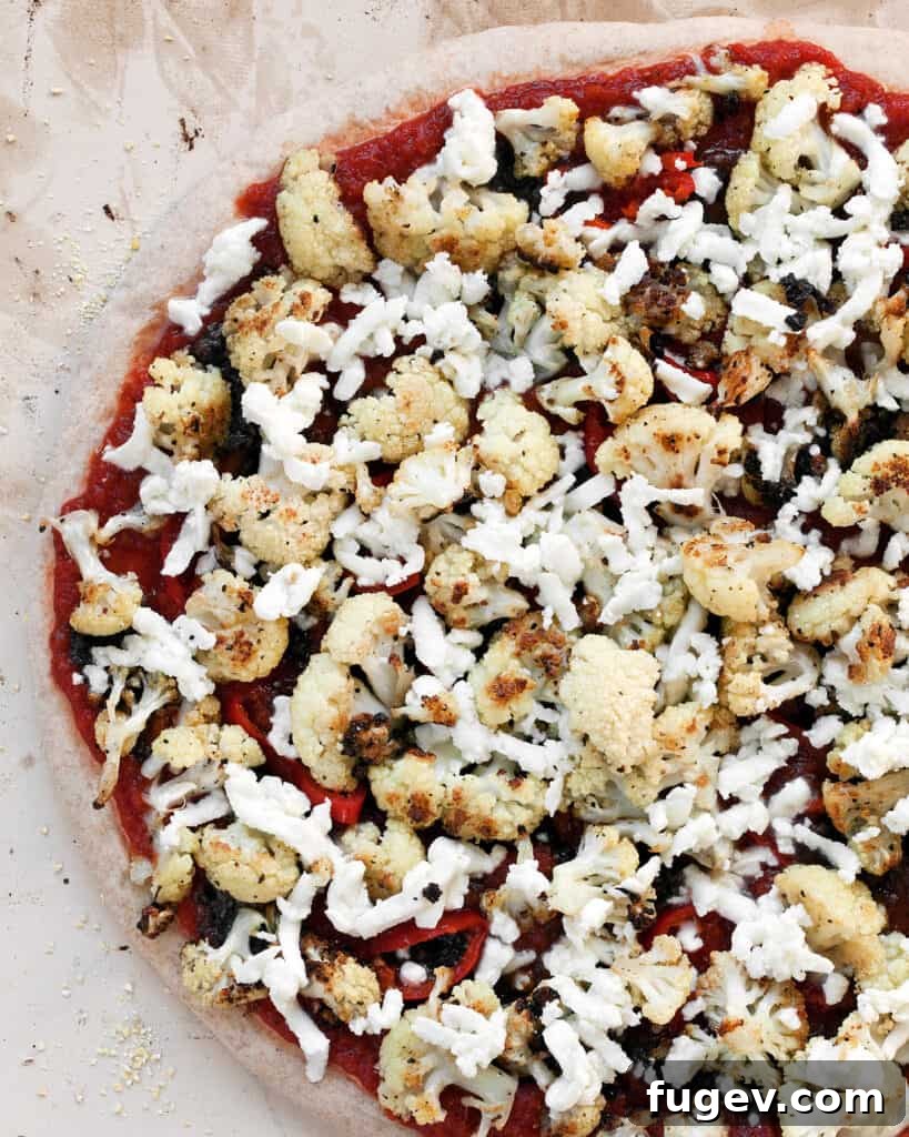 Golden Roasted Cauliflower Tapenade Pizza 7 Pizza dough topped with tomato sauce, olive tapenade, shredded cheese, and roasted cauliflower before baking