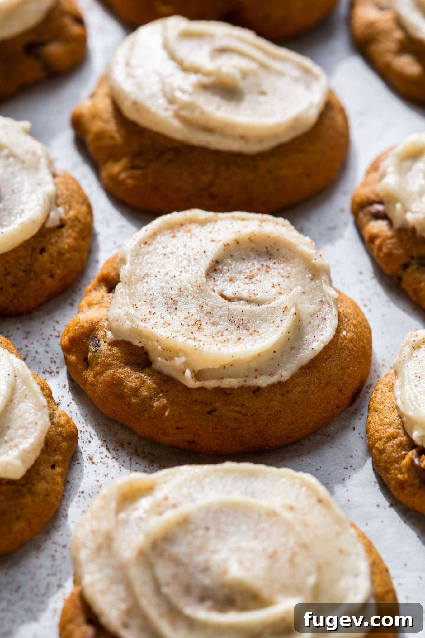 Spiced Pumpkin Chocolate Delights 2 Soft and chewy pumpkin chocolate chip cookies topped with a smooth browned butter icing, close up view showing texture and melty chocolate.