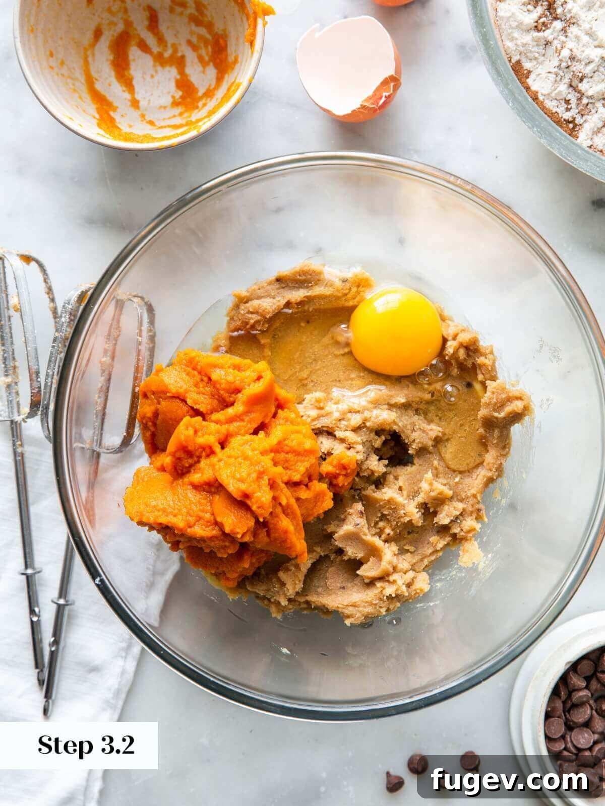 Spiced Pumpkin Chocolate Delights 7 The process of incorporating vibrant pumpkin puree and a single egg into the creamed butter and sugar mixture for cookie dough.