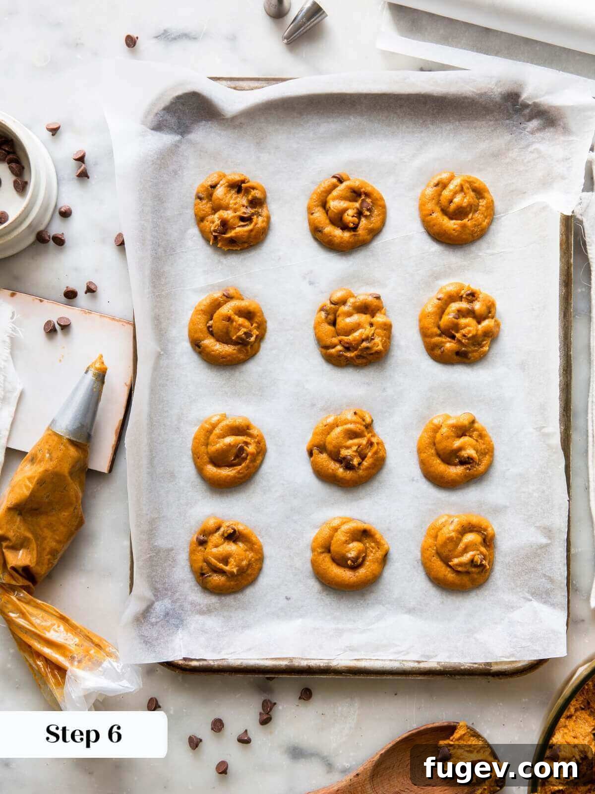 Spiced Pumpkin Chocolate Delights 9 Pumpkin chocolate chip cookie dough neatly piped into uniform circles on a baking sheet, ready for the oven.
