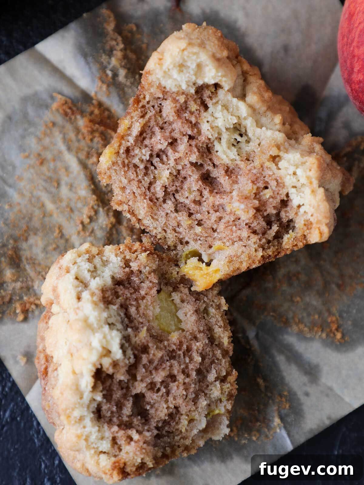 Buttery Crumb Topping 4 Two peach muffins topped with streusel, one split open to reveal its tender interior and the perfect crumb topping.