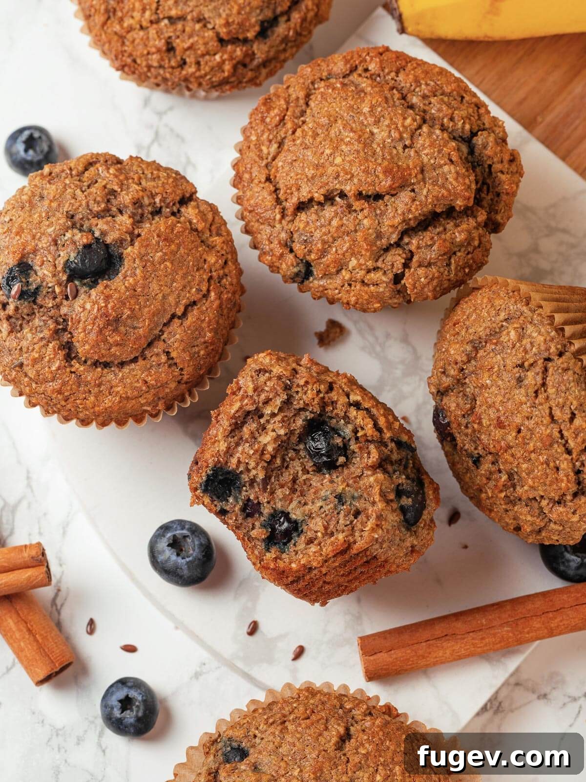 Fiber-Rich Banana Muffins 2 A perfectly baked banana bran muffin with a bite taken out, revealing its moist, tender interior packed with blueberries.