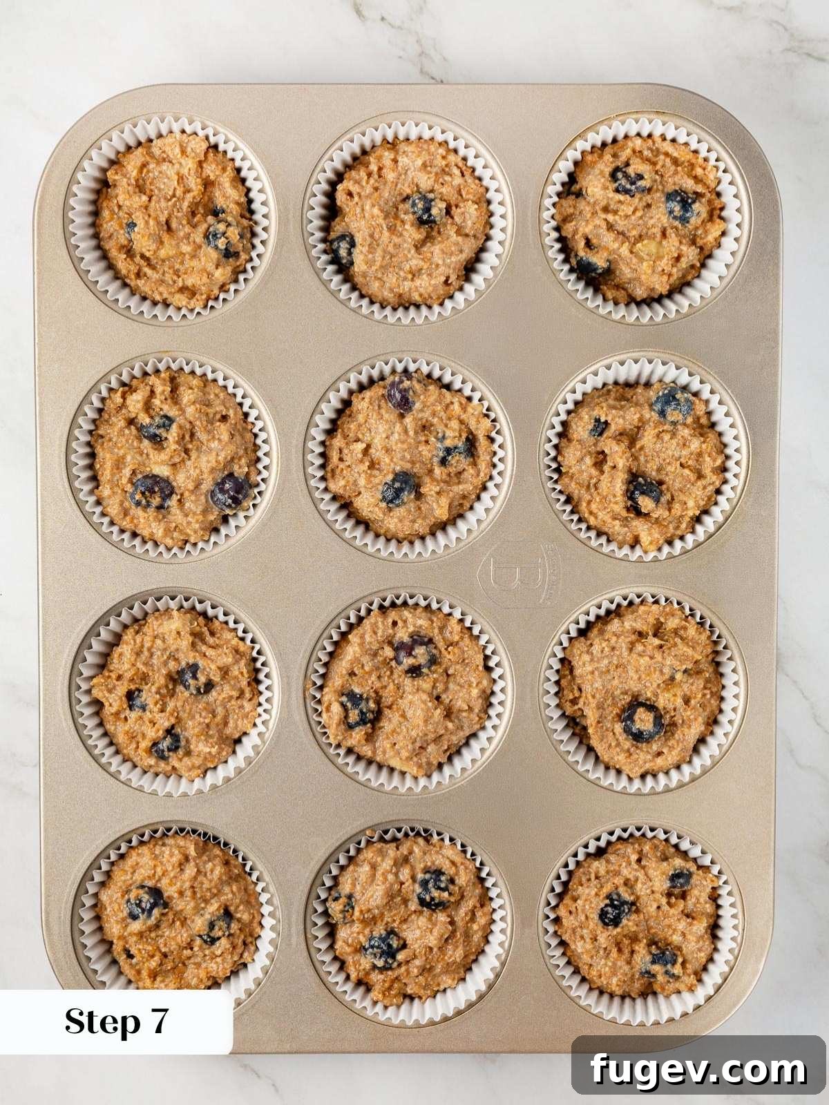 Fiber-Rich Banana Muffins 13 Banana bran muffin batter neatly portioned evenly into paper liners in a muffin tin.