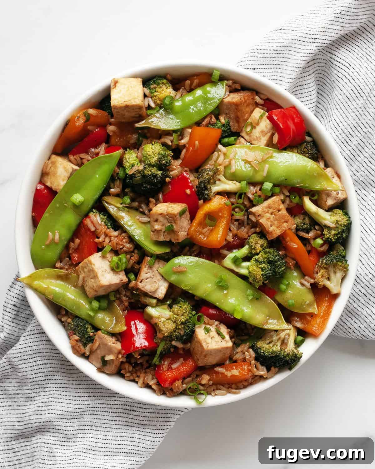 Flavorful Tofu & Veggie Medley 8 Close-up of the finished vegetable tofu stir-fry, garnished with green scallions, in a large skillet.