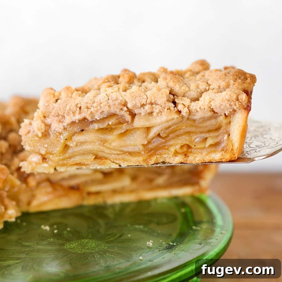 Decadent Caramel Apple Tart 2 A stunning close-up of a Caramel Apple Tart with Cinnamon Streusel Topping, showcasing the golden streusel and a hint of apple filling. Perfect for autumn gatherings.