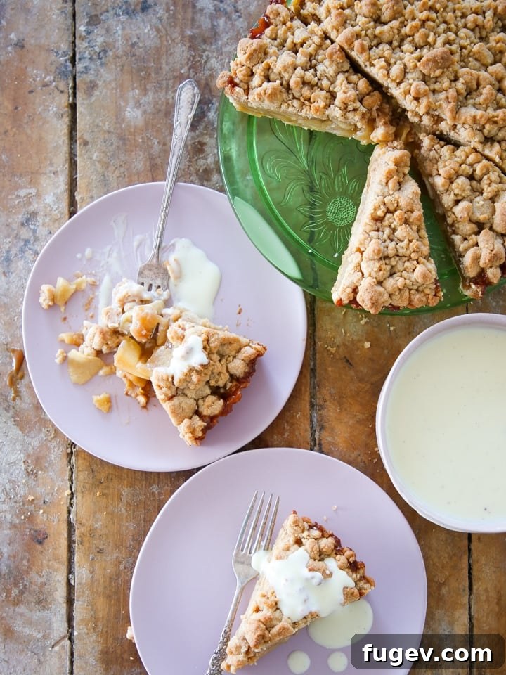 Decadent Caramel Apple Tart 4 A beautifully sliced Caramel Apple Tart, revealing its layers of apple filling and caramel, served on a rustic wood surface. This image highlights the perfect texture of the tart.