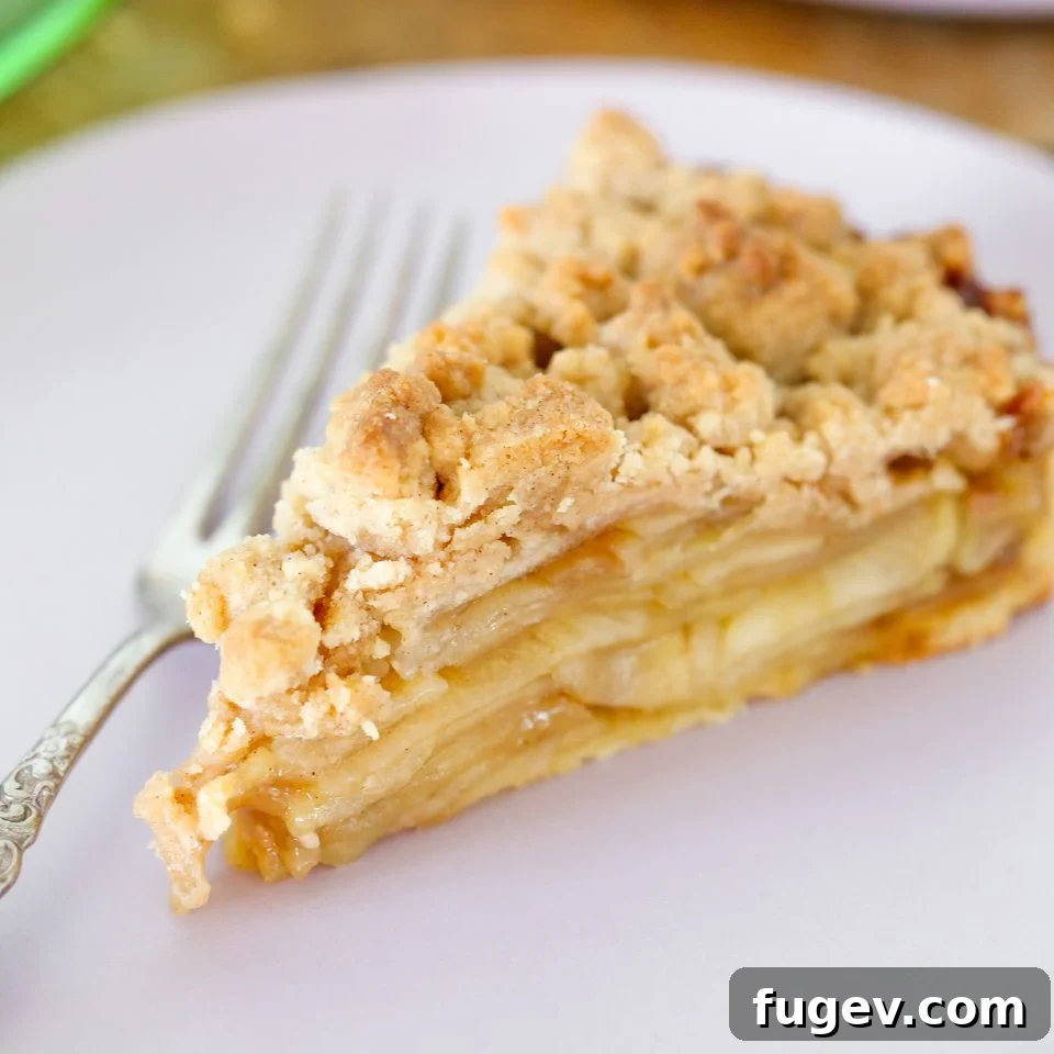 Decadent Caramel Apple Tart 6 Close-up of a rustic-looking Caramel Apple Tart with a generous cinnamon streusel topping, indicating homemade goodness and inviting textures.