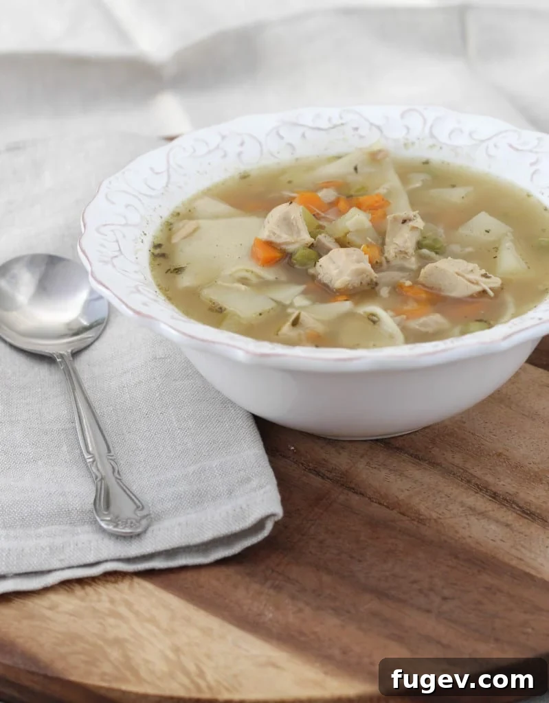 Hearty Homemade Chicken Noodle 2 A steaming bowl of homemade chicken noodle soup with fresh parsley garnish.