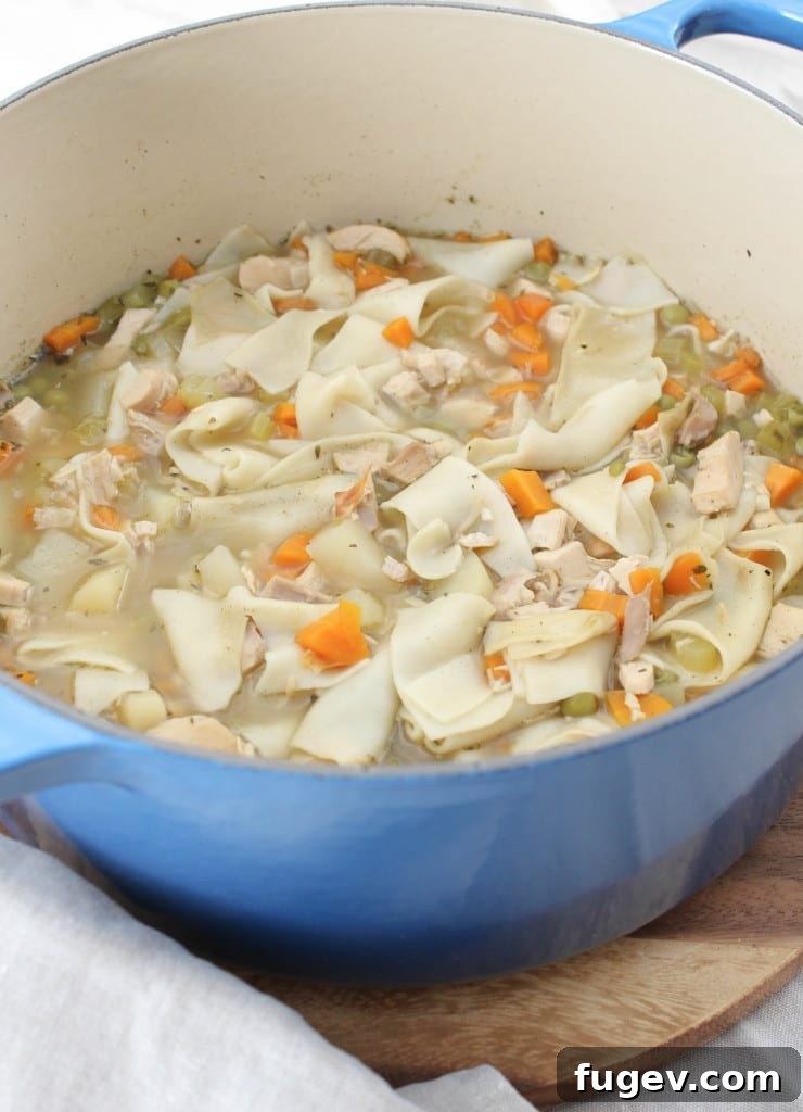 Hearty Homemade Chicken Noodle 4 A Dutch oven filled with simmering chicken noodle soup ingredients.