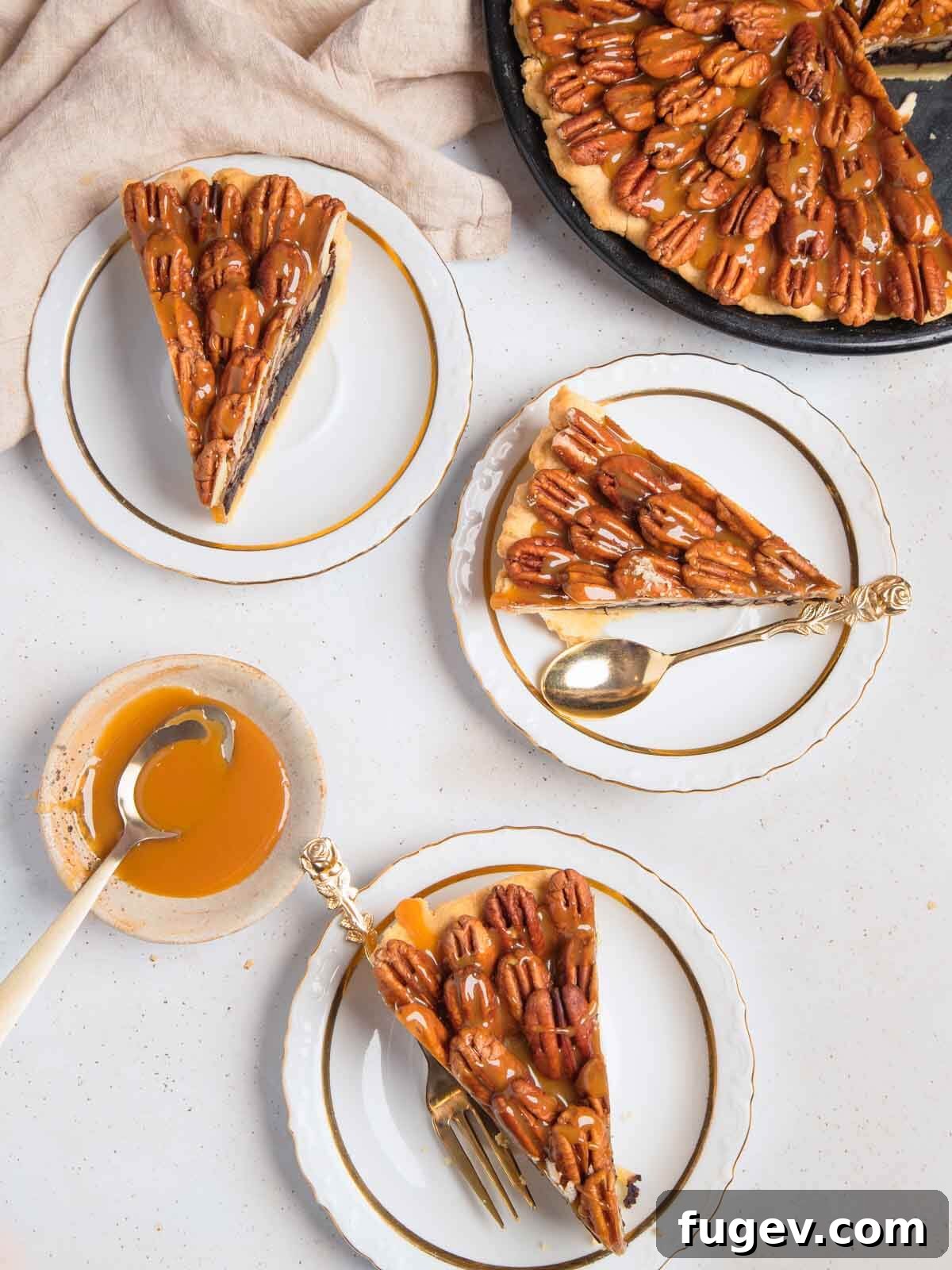 Decadent Chocolate Pecan Pie 2 Three slices of chocolate pecan pie on a white background, highlighting the rich chocolate filling, toasted pecans, and glossy salted caramel topping.