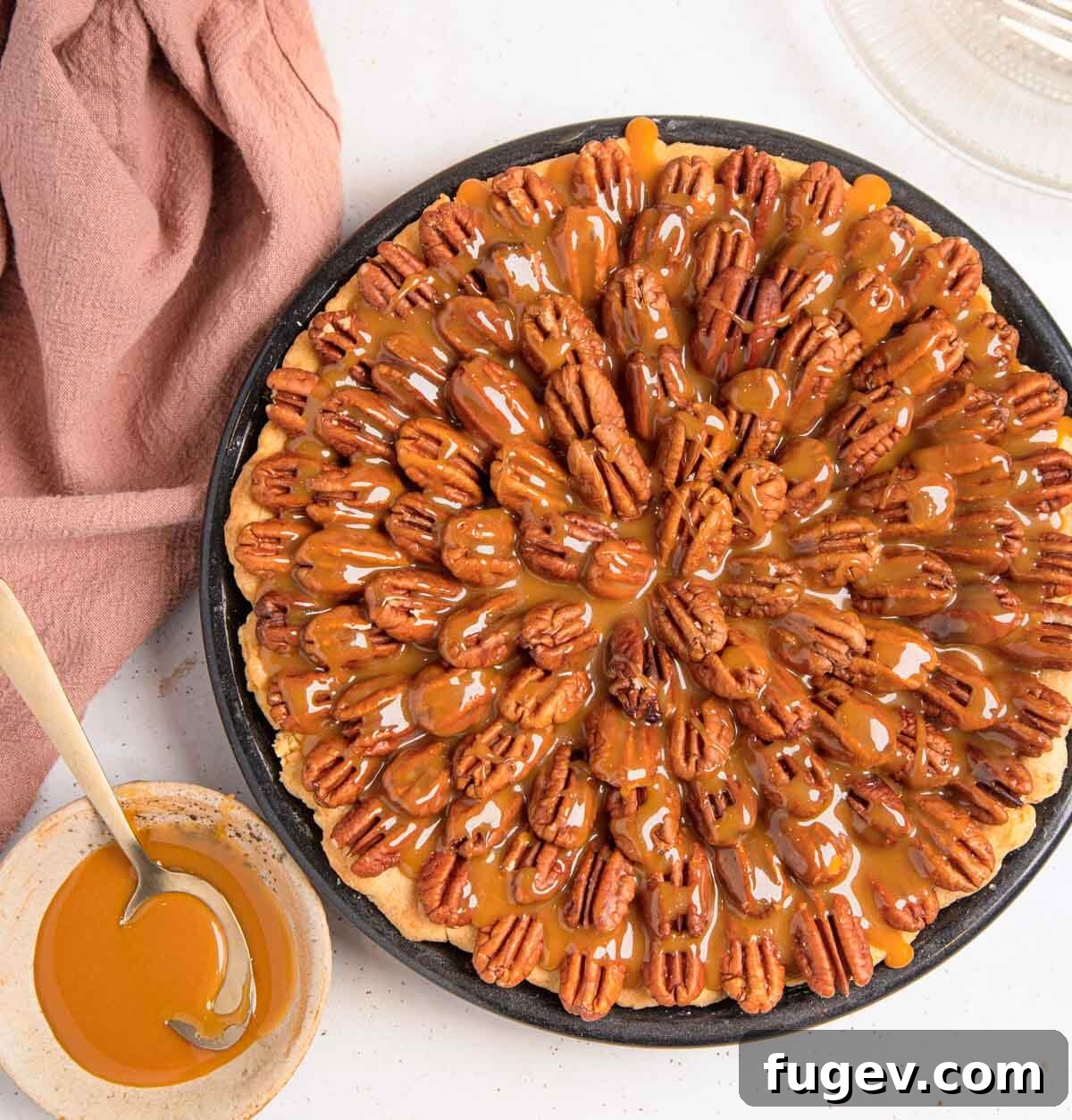 Decadent Chocolate Pecan Pie 3 A whole chocolate pecan pie with a generous drizzle of salted caramel sauce on top, garnished with whole toasted pecans.