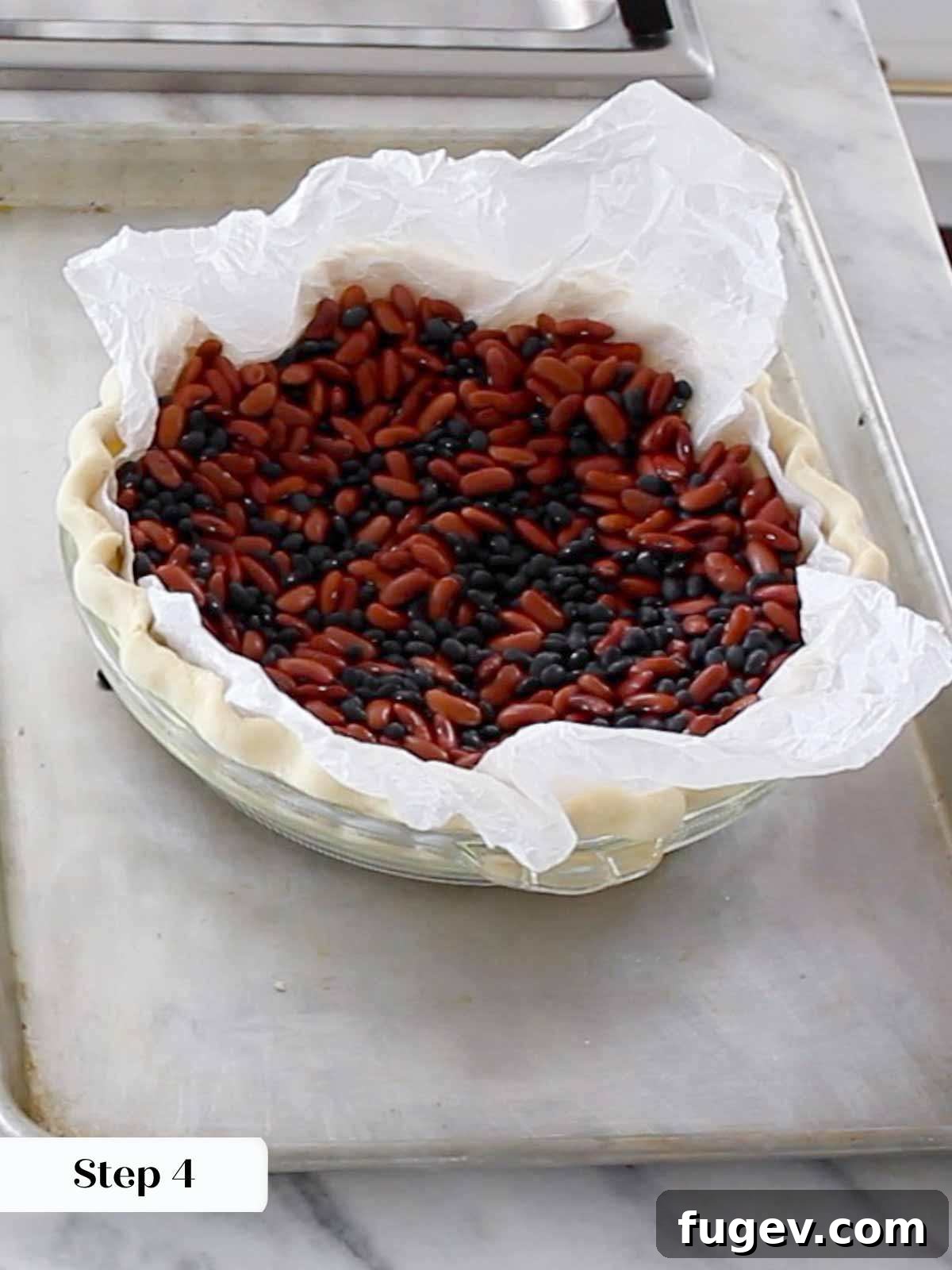 The Perfect Pecan Pie 7 Pie crust being blind baked with dried beans as pie weights, ensuring a flat bottom.