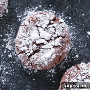 Chocolate Crackle Cookie with powdered sugar on black surface Easy Chocolate Desserts.