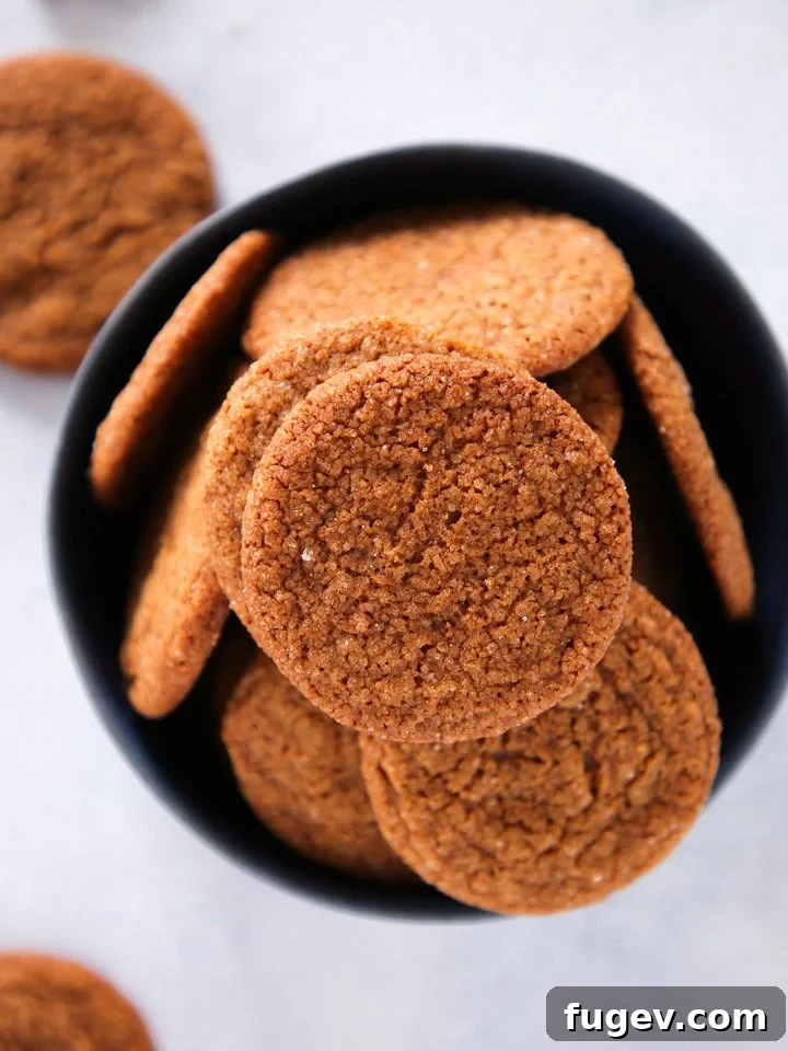 Timeless Gingersnap Cookies 3 A close-up of a plate of golden-brown gingersnaps, dusted with cinnamon sugar, ready to be enjoyed.