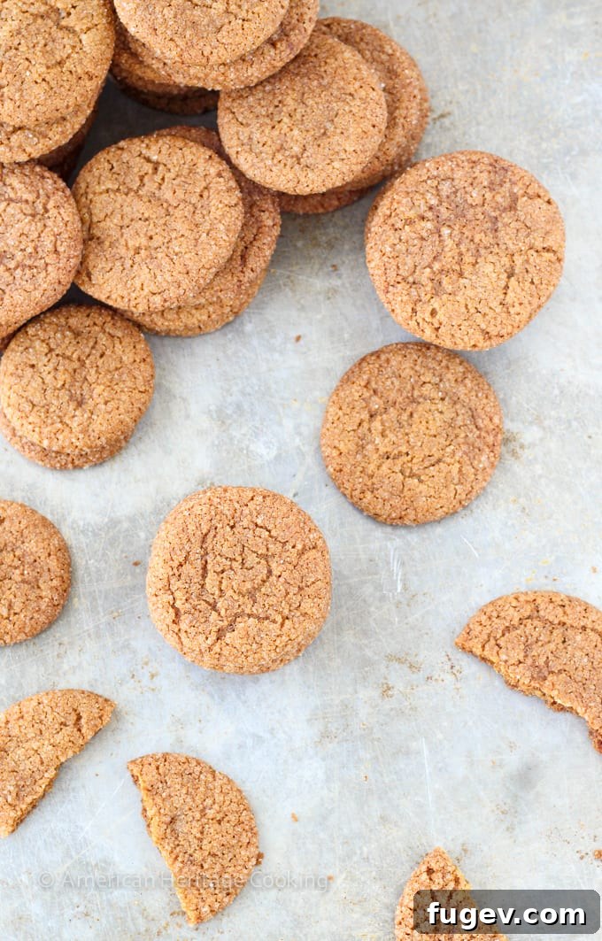 Timeless Gingersnap Cookies 6 A close-up shot of several gingersnap cookies on a white plate, showcasing their texture and inviting aroma.