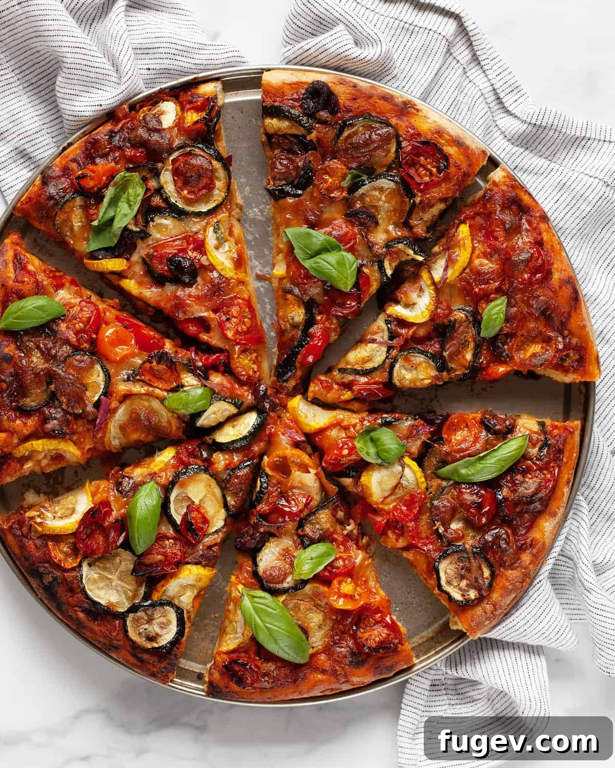 Garden Roast Pizza 7 A close-up shot of a sliced roasted vegetable pizza, revealing the perfectly baked crust and vibrant, melted toppings.
