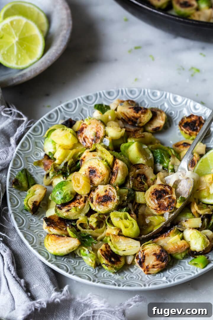 Zesty Lime Ginger Brussels Sprouts and Leeks 4 Plated Brussels Sprouts and Leeks with a generous drizzle of lime-ginger butter sauce on a grey plate.