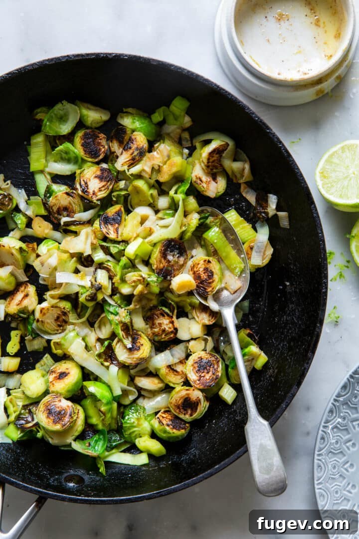 Zesty Lime Ginger Brussels Sprouts and Leeks 5 Brussels Sprouts and Leeks with Lime-Ginger Butter in a skillet with a serving spoon, showcasing the delicious coating.
