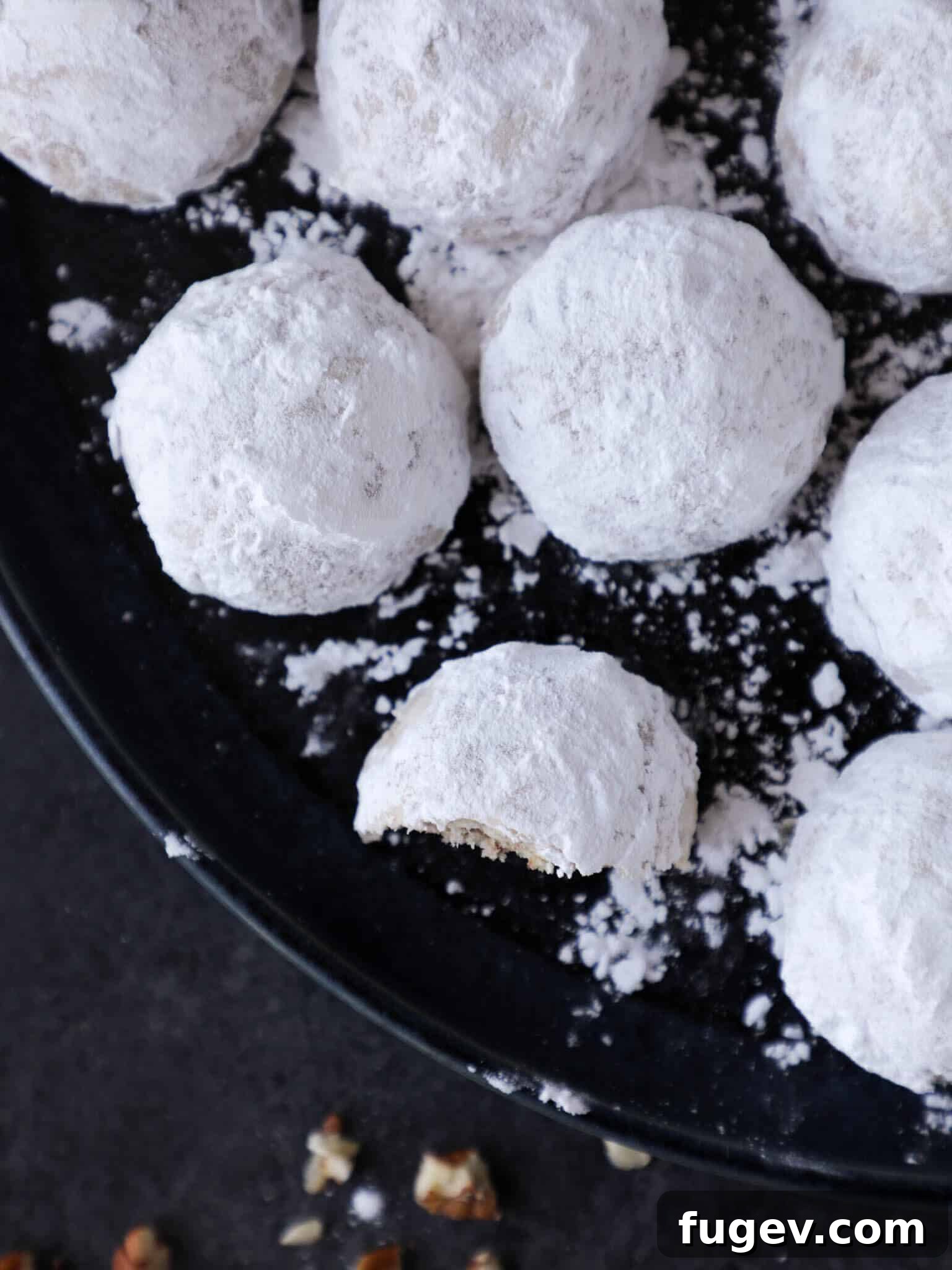 Melt-in-Your-Mouth Snowball Cookies 4 Snowball cookies covered in powdered sugar, ready to be served.
