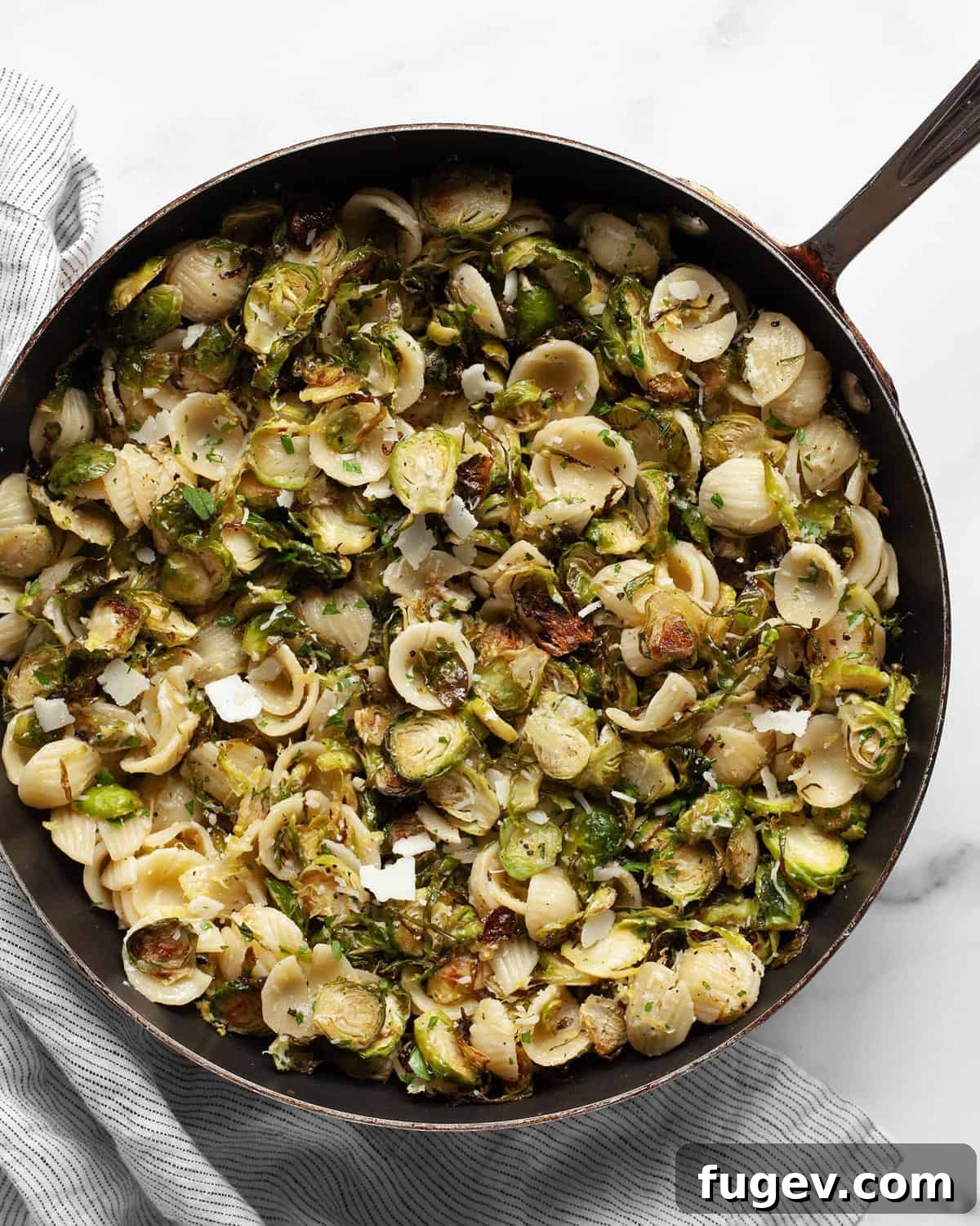 Caramelized Brussels Sprout Pasta 2 A vibrant roasted Brussels sprout pasta dish served in a large skillet, garnished with fresh herbs, ready to be enjoyed.
