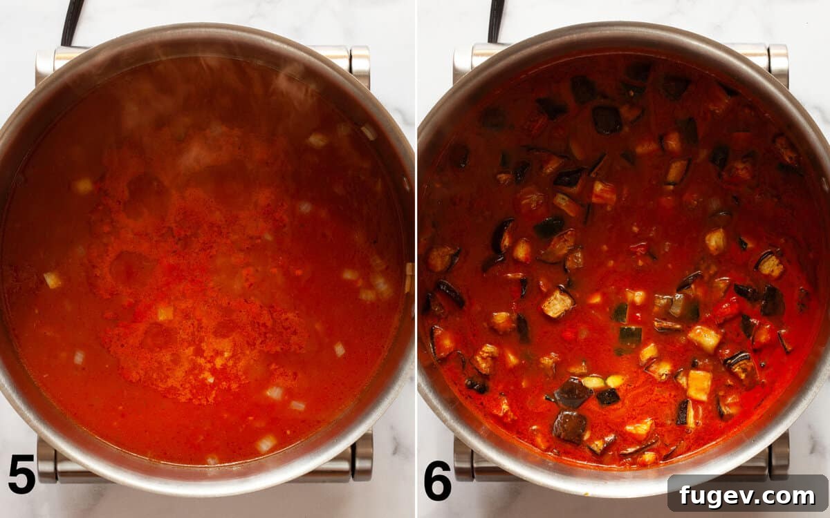 Mediterranean Eggplant and Chickpea Stew 6 A close-up view of a large pot filled with the simmering eggplant and zucchini stew, showcasing the roasted vegetables and chickpeas immersed in the rich, spiced tomato broth.