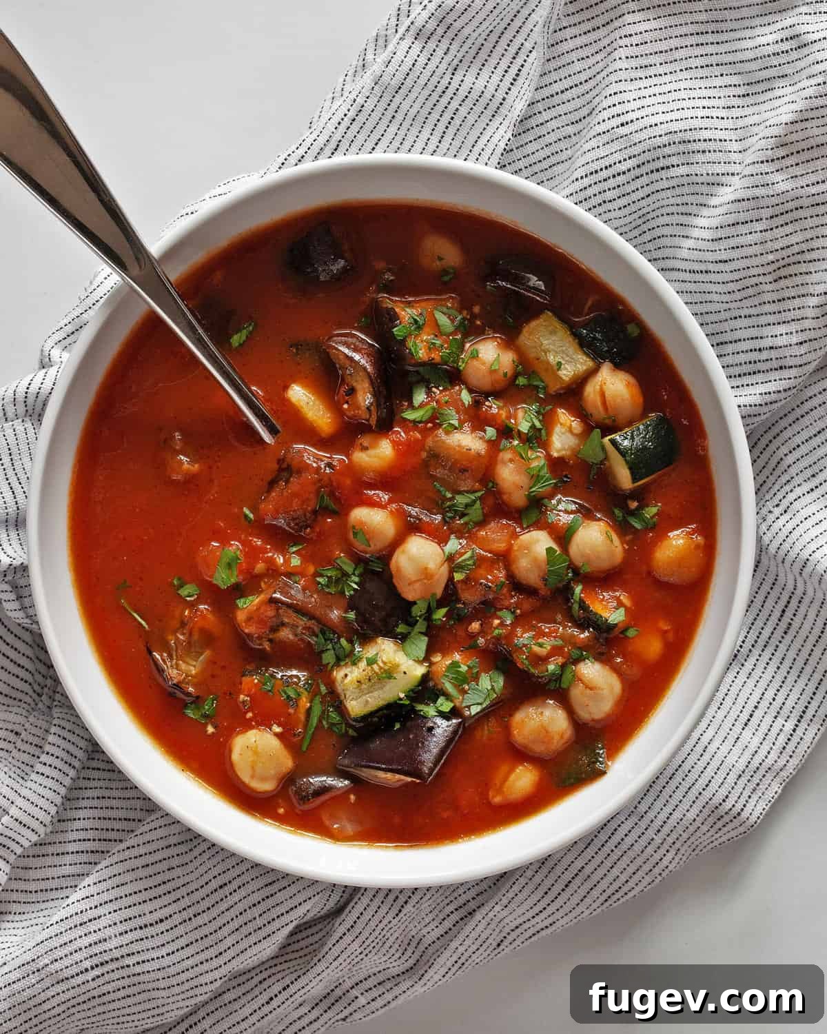 Mediterranean Eggplant and Chickpea Stew 7 A single bowl of robust zucchini tomato eggplant stew, garnished with fresh herbs, ready to be enjoyed as a comforting meal.
