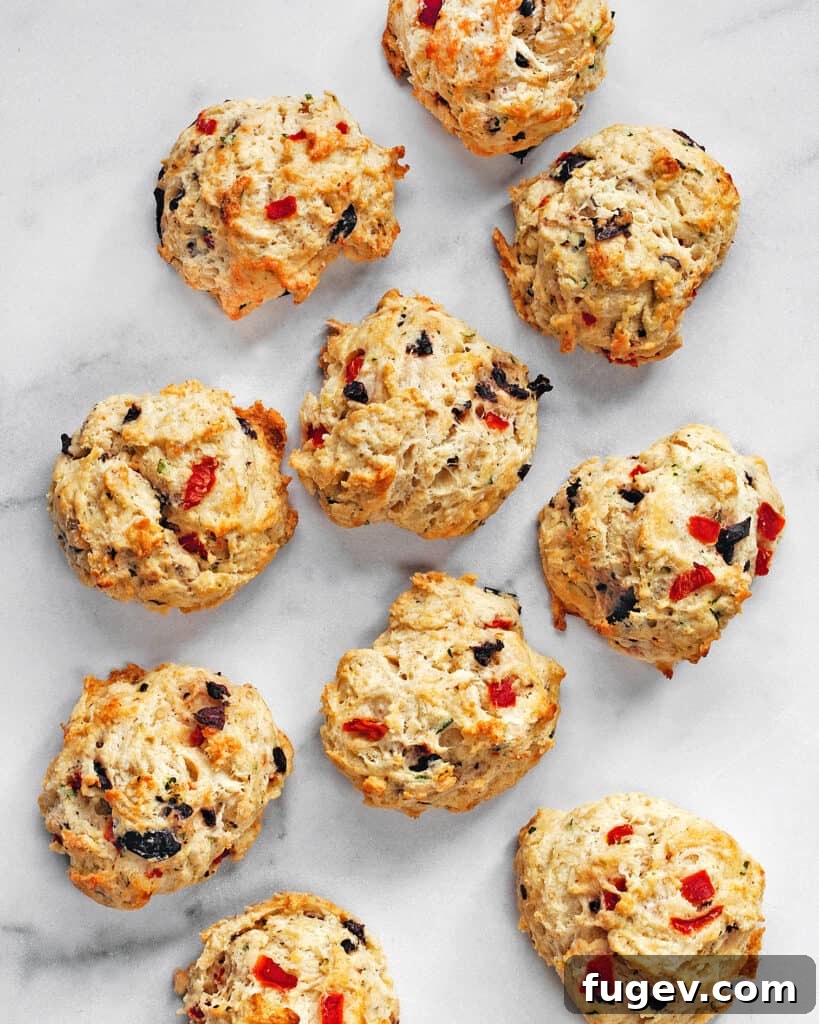 Crimson Chevre Scones 3 Close-up of a halved biscuit revealing roasted red peppers, olives, and melted goat cheese inside.