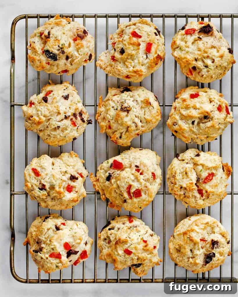 Crimson Chevre Scones 4 Freshly baked red pepper biscuits arranged on a cooling wire rack.