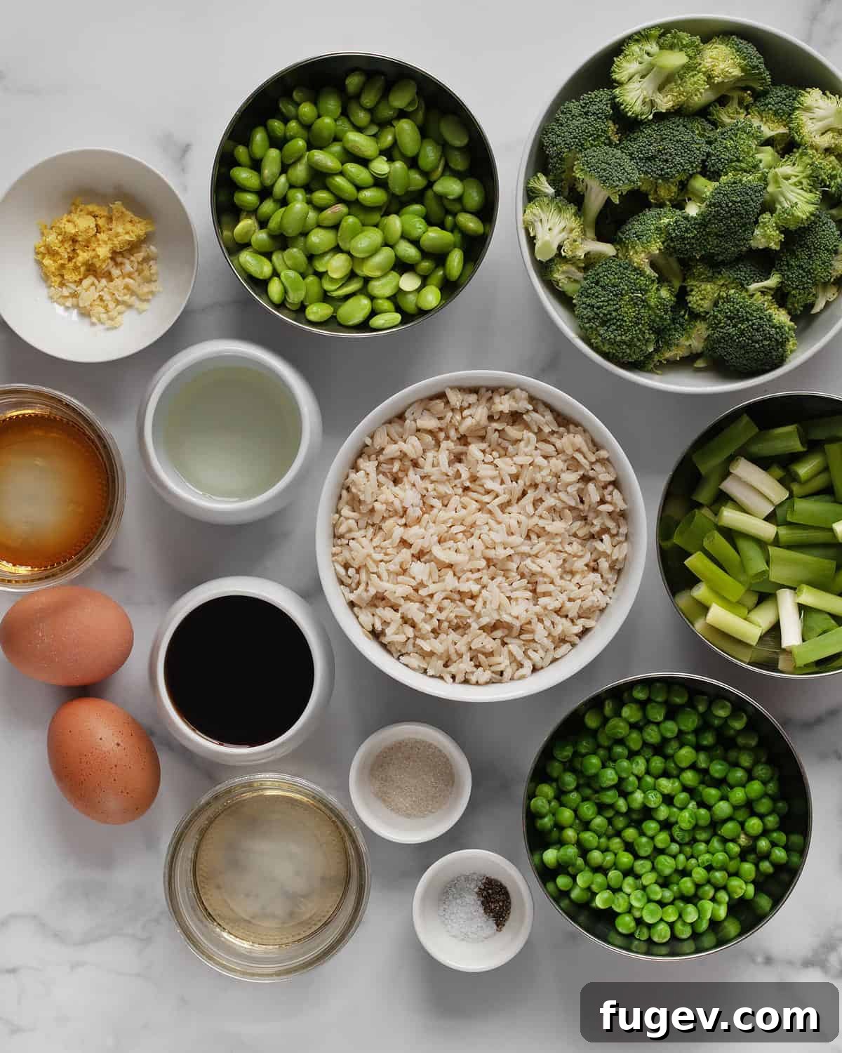 Nutrient-Packed Broccoli, Edamame, and Pea Fried Rice 3 Ingredients for broccoli fried rice laid out: broccoli, peas, edamame, scallions, cooked brown rice, eggs, cooking oil, rice vinegar, fresh ginger, minced garlic, and low-sodium soy sauce.