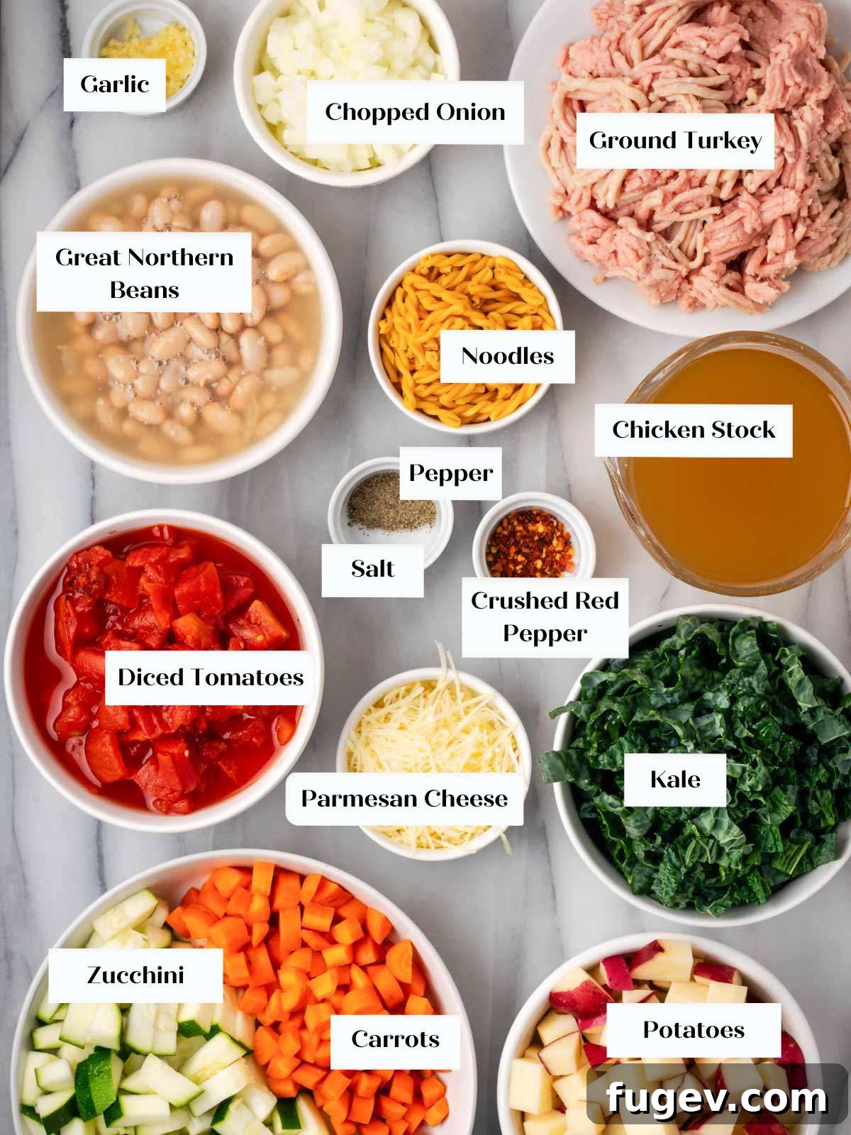 Wholesome Ground Turkey Soup 3 A colorful array of fresh ingredients for ground turkey soup, including vegetables, herbs, and spices, laid out on a marble surface.