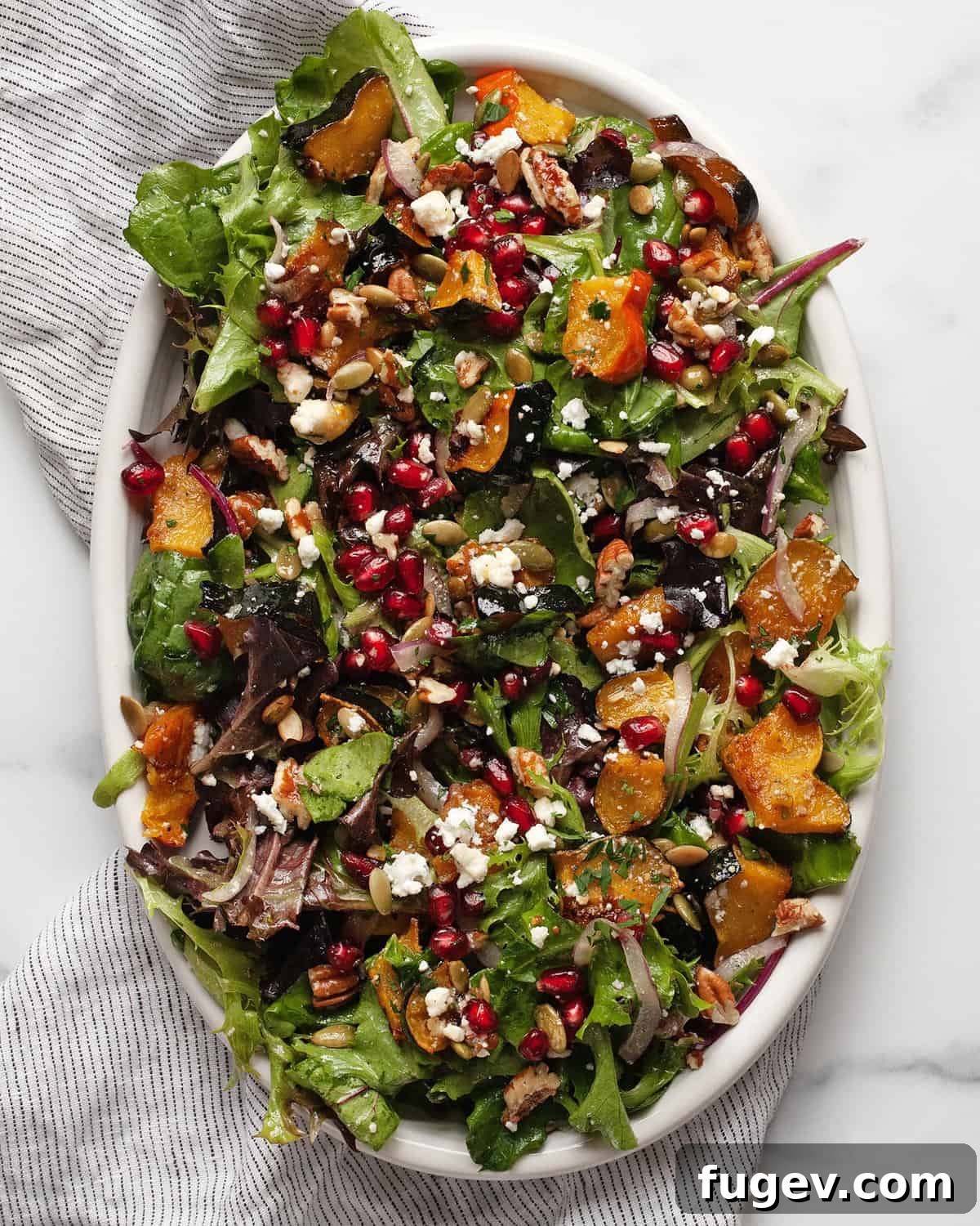 Golden Harvest Squash Salad 2 A vibrant roasted squash salad arranged beautifully on an oval serving platter, showcasing rich autumnal colors and diverse textures.